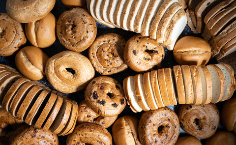 Gluten-free bagels, bread, and rolls from Outside The Breadbox arranged on a lifestyle board