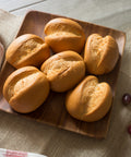 Gluten-free brown rice dinner rolls arranged on a wooden board, ready to serve