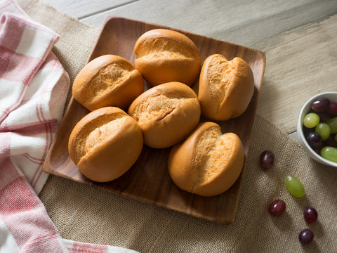 Gluten-free brown rice dinner rolls arranged on a wooden board, ready to serve