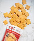 Gluten-free habanero cheddar crackers from Outside The Breadbox with bag and crackers scattered on a white surface