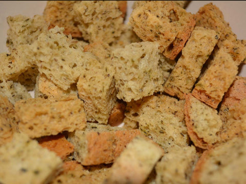 Close-up of gluten-free herb croutons showing toasted texture and seasoning throughout the bread