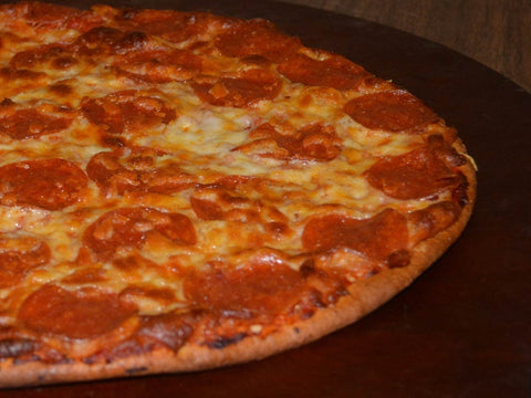 Whole gluten-free pepperoni pizza with melted cheese and a crisp baked crust