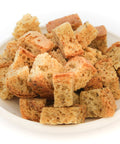 Bowl of gluten-free croutons showing lightly toasted texture and herb seasoning